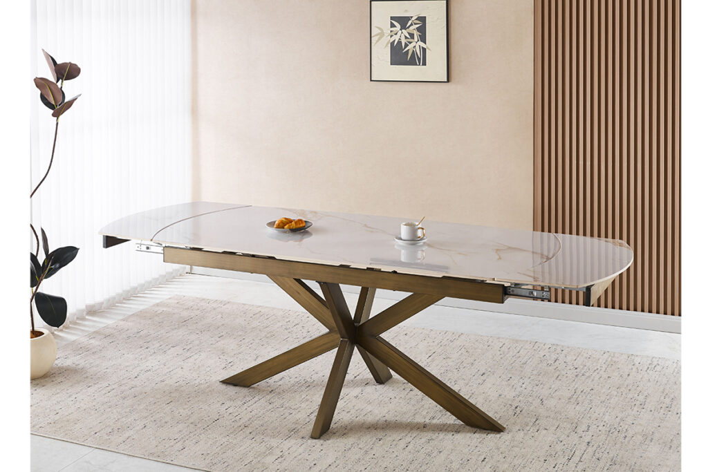 Marble-top dining table with a geometric wooden base, set with croissants and a coffee cup in a bright room.