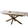 Modern marble-top dining table with an angular wooden base, set with a plate of croissants and a cup of coffee for breakfast.