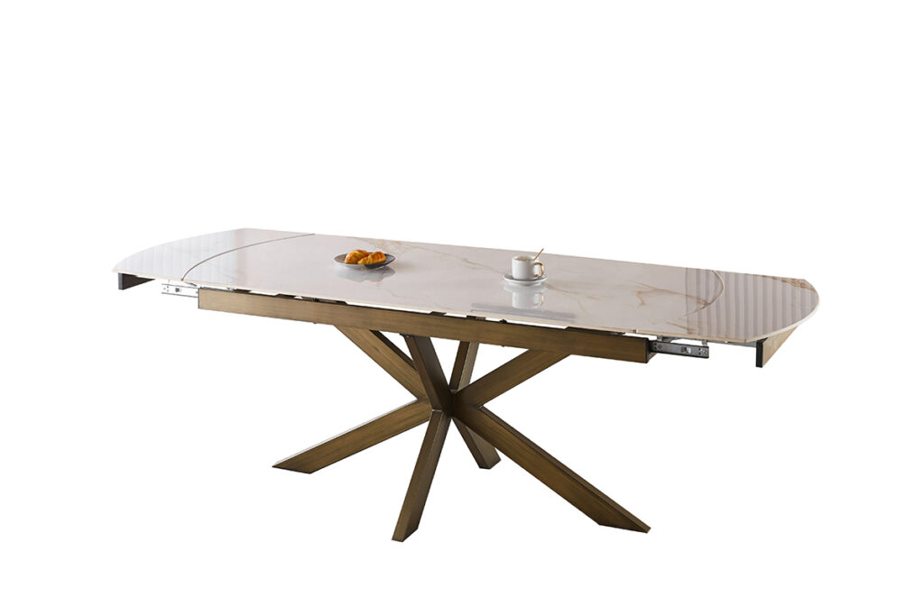 Modern marble-top dining table with an angular wooden base, set with a plate of croissants and a cup of coffee for breakfast.